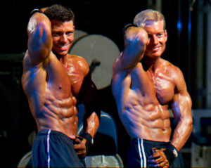 Jonathan Lawson and Steve Holman flexing abs