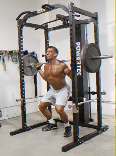 Jonathan squatting in a home gym rack
