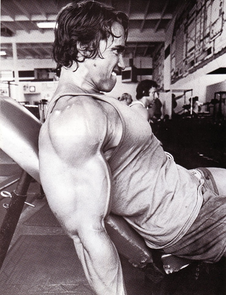 Arnold doing incline curls