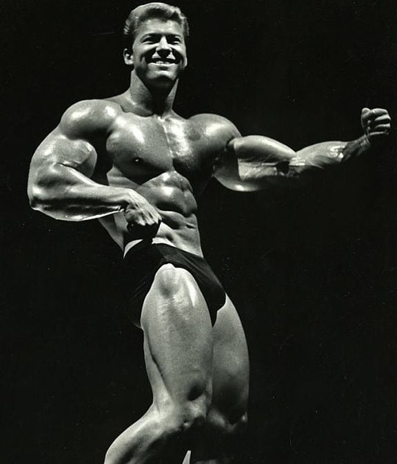 Larry Scott on stage with his arm out