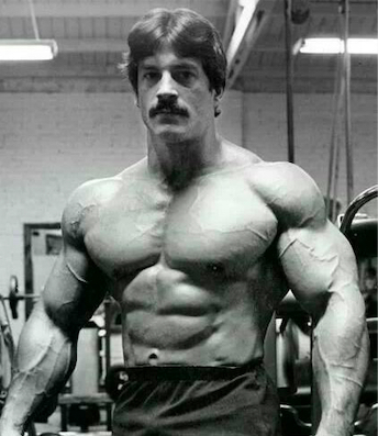 Mike Mentzer in a relaxed pose in a gym