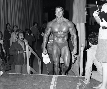Arnold walking up stairs onto the contest stage
