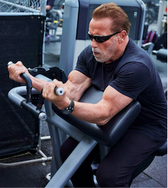 Arnold using a preacher curl machine at age 75