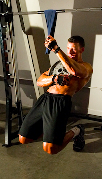 Jonathan demonstrating sissy squats while holding a weight plate